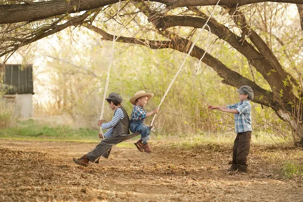 Kinderen op schommels zonnige zomerdag — Stockfoto