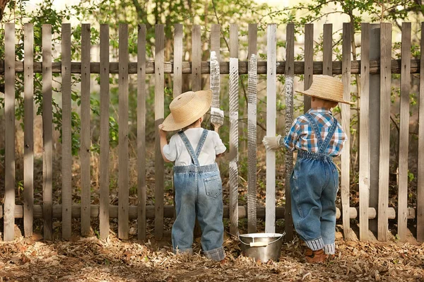 Boys paint old fence — Stock Photo, Image