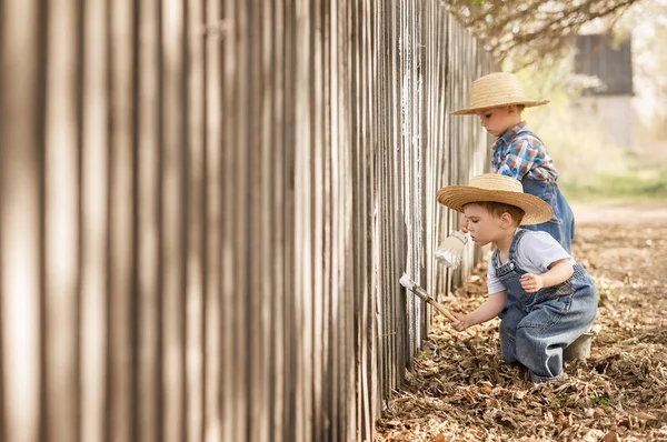 Boys paint old fence — Stock Photo, Image