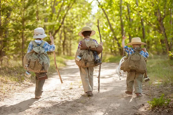 Rapazes numa estrada florestal com mochilas — Fotografia de Stock
