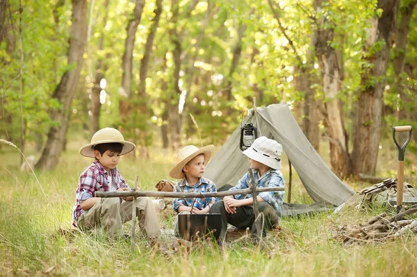 Resto de niños con una tienda de campaña y una hoguera en la naturaleza —  Fotos de Stock