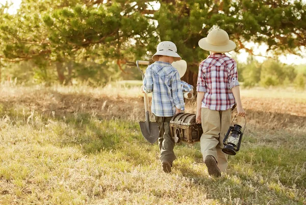 Kinder suchen Schatzsucher unter einem Baum mit Stamm — Stockfoto