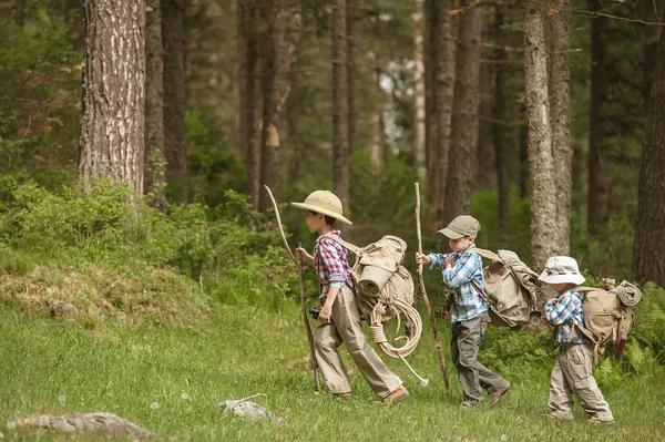 Boys travelers on a forest trail with backpacks — Stock Photo, Image
