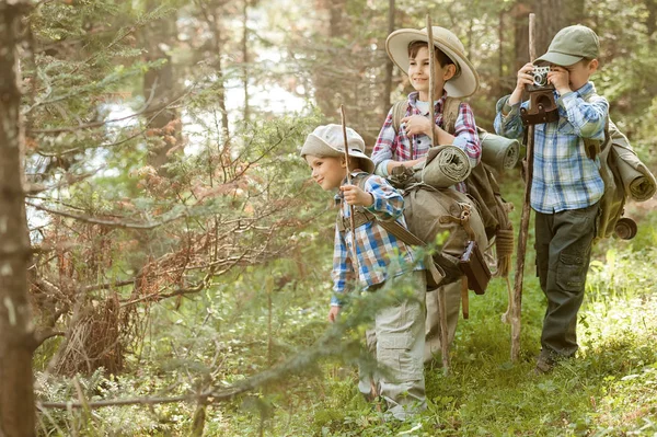 Rapazes viajantes em uma trilha florestal com mochilas — Fotografia de Stock
