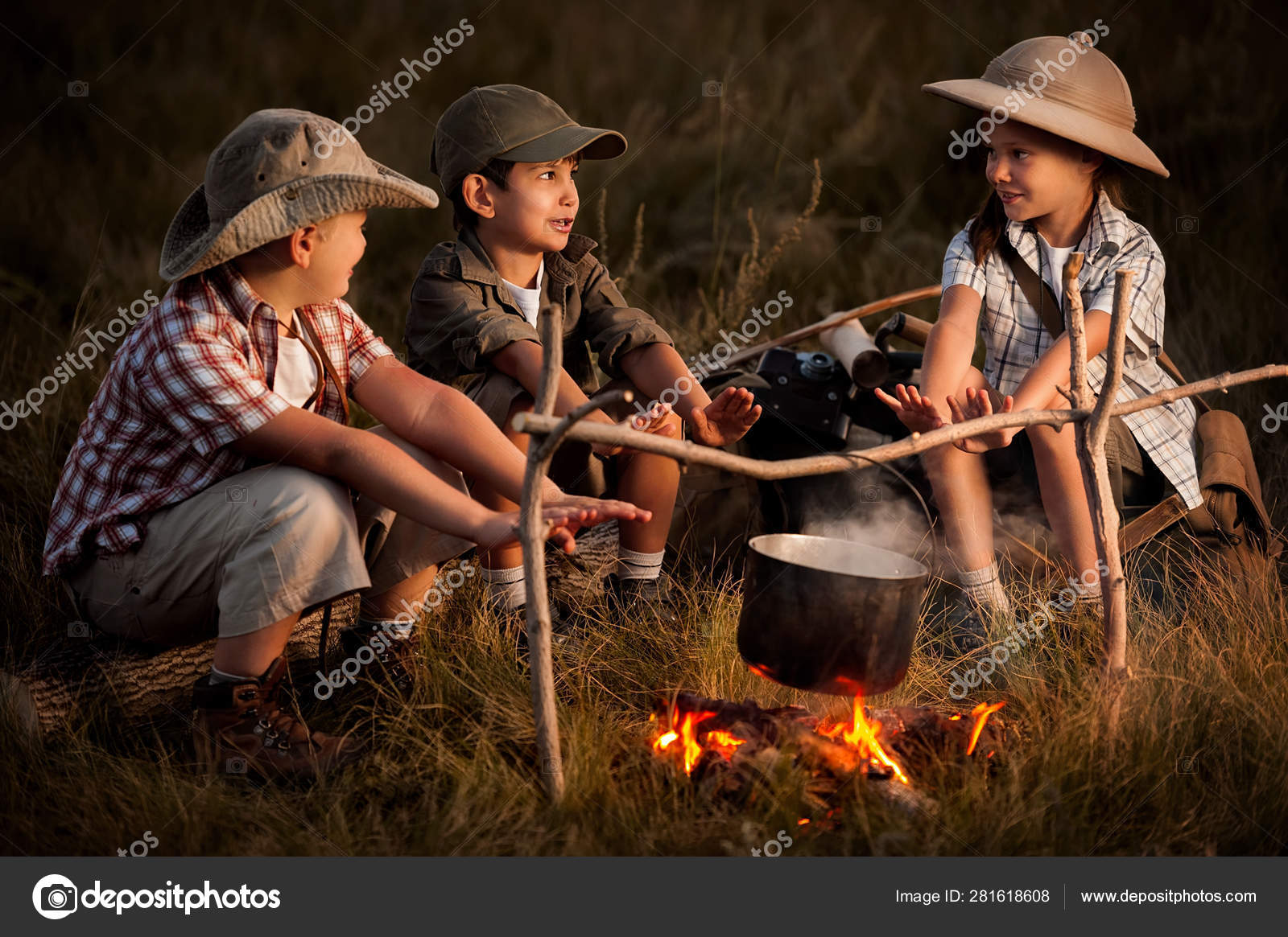Группа Детей, Сидящих Вокруг Костра Путешественников Стоковое Фото.