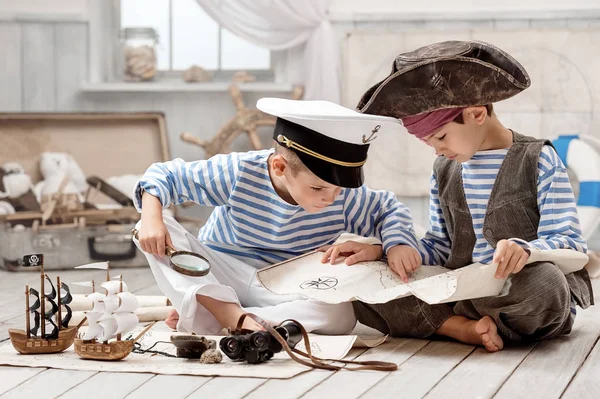 Хлопці, одягнені як капітан піратів і читають карту подорожей — стокове фото