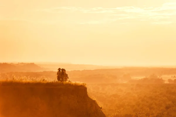 Enfants avec des touristes sur une falaise au coucher du soleil — Photo