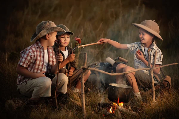 Grupo de niños sentados alrededor de los viajeros fogata —  Fotos de Stock