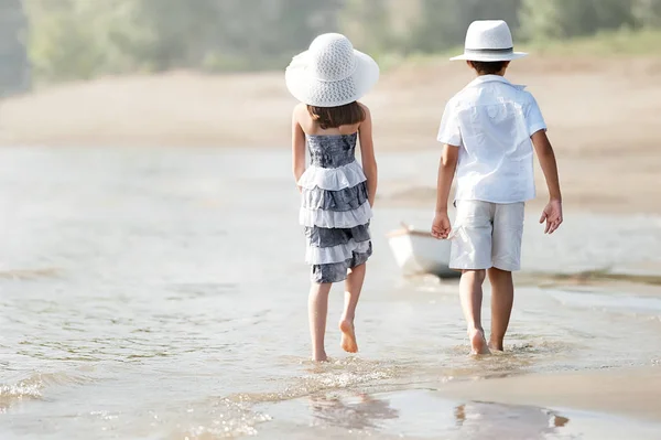 Niño con chica caminando por la orilla del lago —  Fotos de Stock