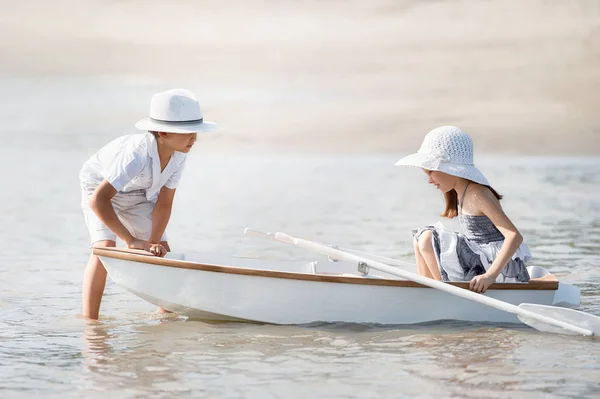 Niño con una chica montando en un barco —  Fotos de Stock