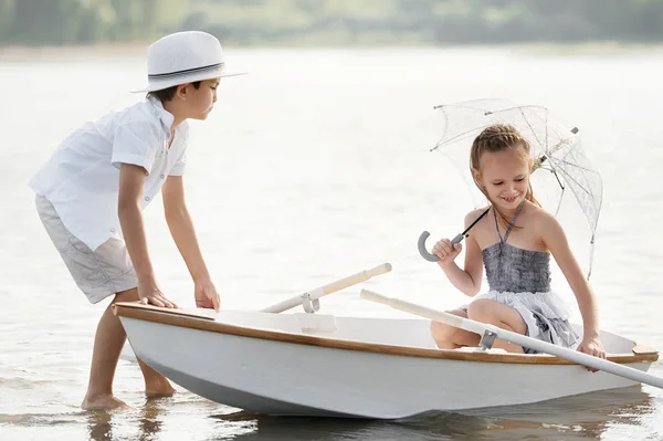 Boy with a girl riding on a boat — Stock Photo, Image