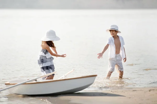 Niño con una chica montando en un barco —  Fotos de Stock