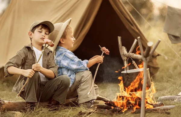 Två av barnen sitter runt lägerelden resenärer — Stockfoto