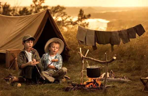 Dos de los niños sentados alrededor de los viajeros fogata —  Fotos de Stock