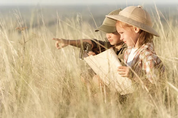 Jongen op zoek door verrekijker in een dik droog gras — Stockfoto
