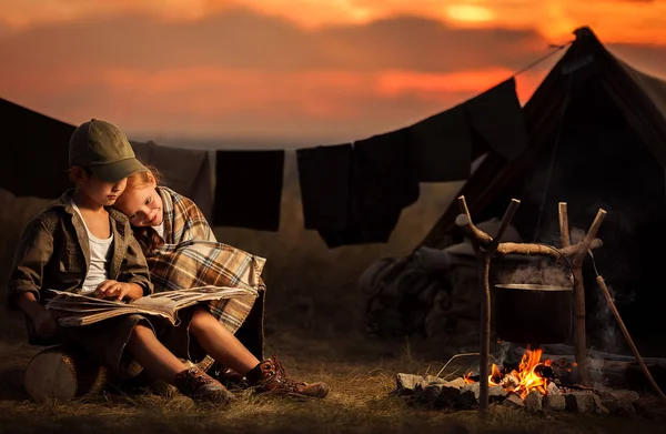 Due bambini seduti intorno al fuoco viaggiatori — Foto Stock