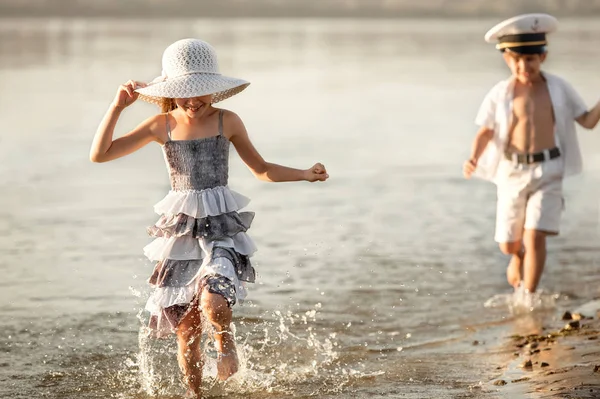 Boy with a girl running along the lake shore — Stock Photo, Image