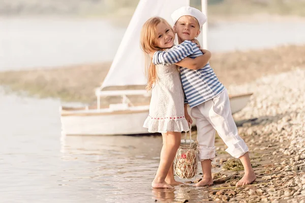 Boy with girl walking along the shore of the lake — Stock Photo, Image