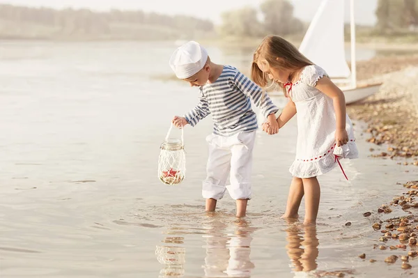 Boy with girl walking along the shore of the lake — Stock Photo, Image