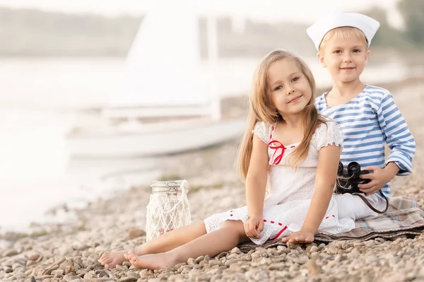 男孩与一个女孩坐在沙滩上，看着远处 — 图库照片