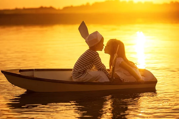 Pojke med en flicka som flyter på en båt rodde över sjön — Stockfoto