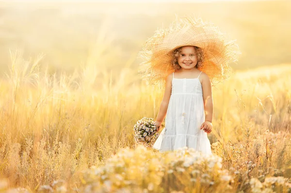 Liten flicka med en bukett vilda blommor — Stockfoto