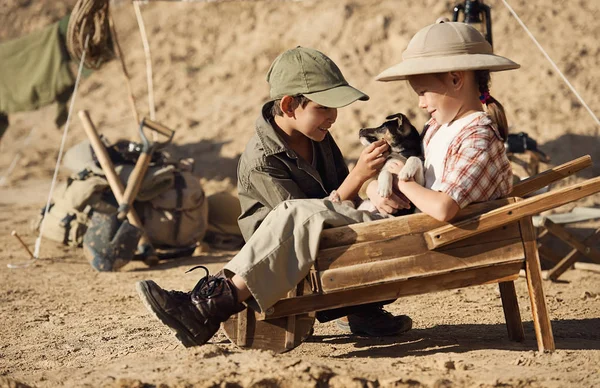 Niño y niña jugando con un arqueólogo cachorro en la excavación —  Fotos de Stock