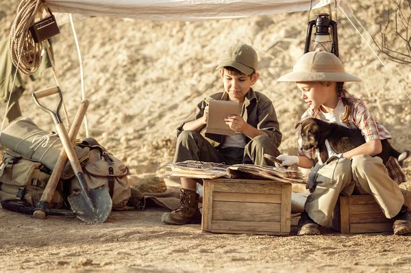 Children archaeologists take notes in a notebook on the excavations conducted — Stock Photo, Image