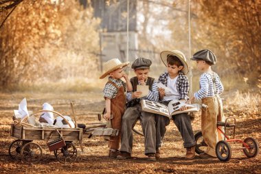 Çocuklar bir yaz gününün bahçesinde ağaçların altında oynarlar.