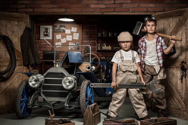 Хлопчики-механік з інструментами в машині в гаражі — стокове фото
