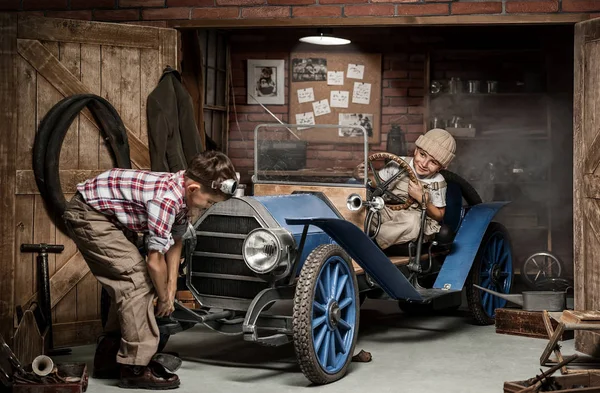 Chłopcy-mechanik z narzędziami w samochodzie w garażu — Zdjęcie stockowe