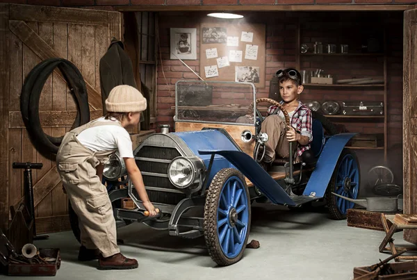 Jungenmechaniker mit Werkzeug im Auto in der Garage — Stockfoto