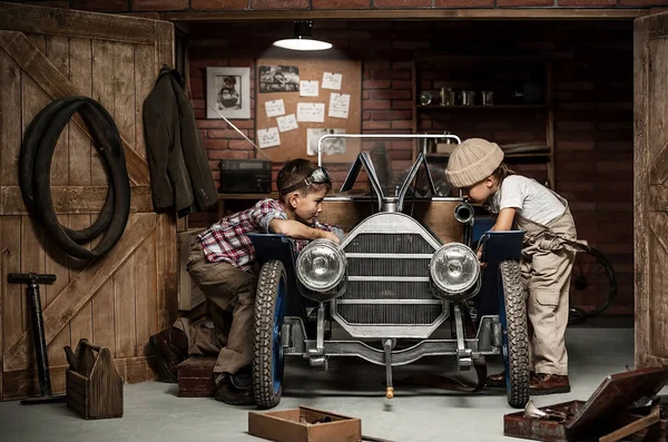Jungenmechaniker mit Werkzeug im Auto in der Garage — Stockfoto