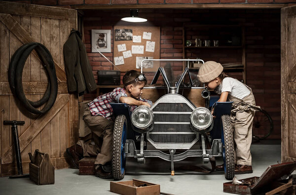 Boys-mechanic with tools in the car in the garage