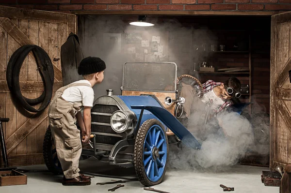 Jungenmechaniker mit Werkzeug im Auto in der Garage — Stockfoto