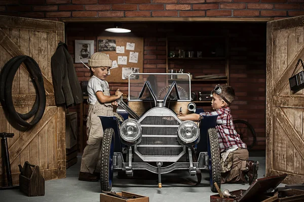 Jungenmechaniker mit Werkzeug im Auto in der Garage — Stockfoto