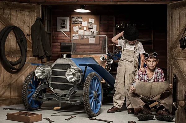 Jongens-monteur met gereedschap in de auto in de garage — Stockfoto