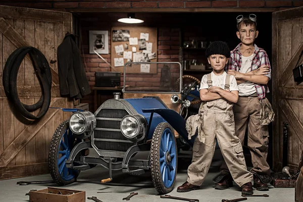 Meninos-mecânico com ferramentas no carro na garagem — Fotografia de Stock