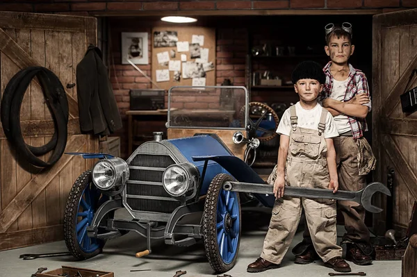Pojkar-mekaniker med verktyg i bilen i garaget — Stockfoto