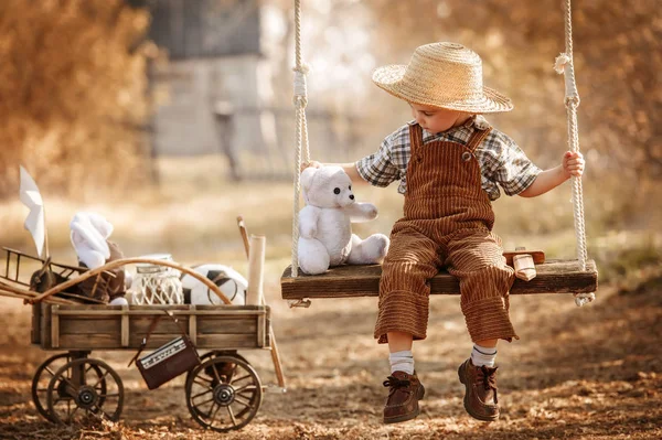 Kleiner Junge mit Spielzeug auf einer Schaukel — Stockfoto