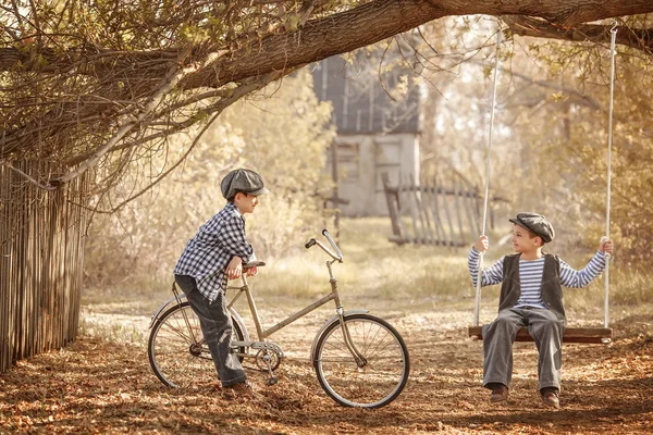 Chłopcy bawią się na ulicy i jeżdżą rowerem letnim dniem — Zdjęcie stockowe