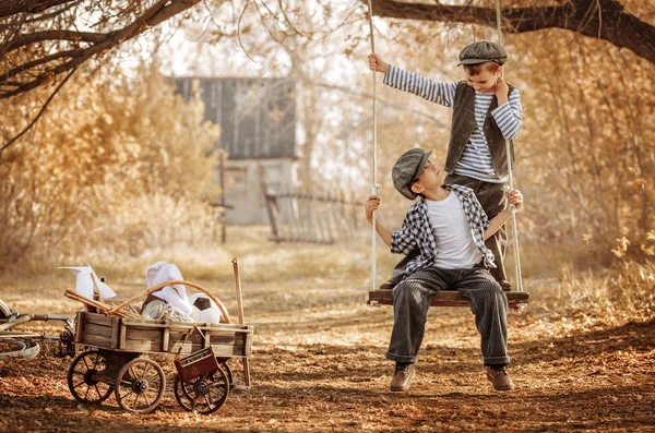 Niños balanceándose en el columpio en el patio — Foto de Stock