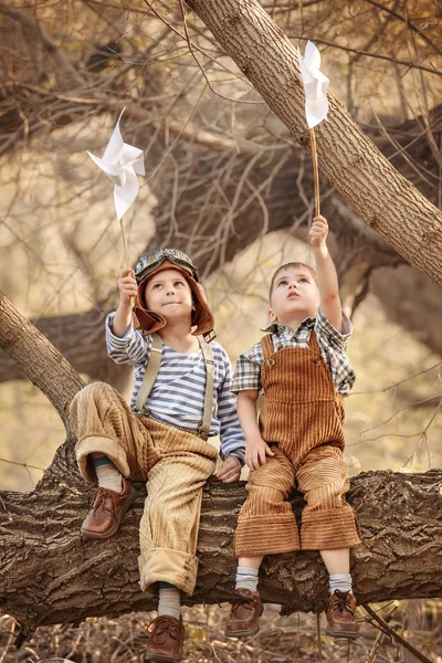 Niños jugando con cubiertas en el jardín en una rama de árbol —  Fotos de Stock