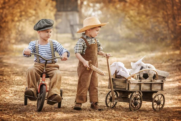 Two little boys playing in the street with toys — Stock Photo, Image