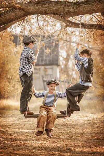 Barn gungande på gungor sommardag — Stockfoto