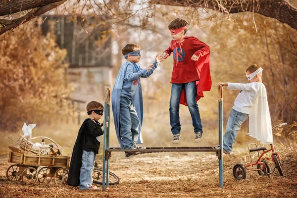 Діти, одягнені як супергерої, грають на ігровому майданчику літнього дня — стокове фото