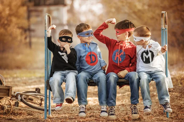 Süper kahraman kılığına girmiş dört çocuk birbirlerinin gücünü gösteriyor. — Stok fotoğraf