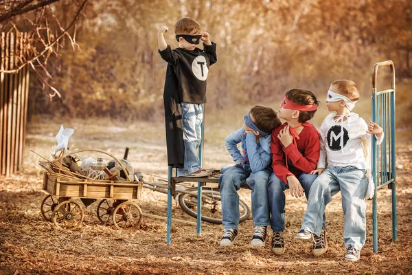 Vier jongens gekleed als superhelden pronken met de kracht van elkaar — Stockfoto