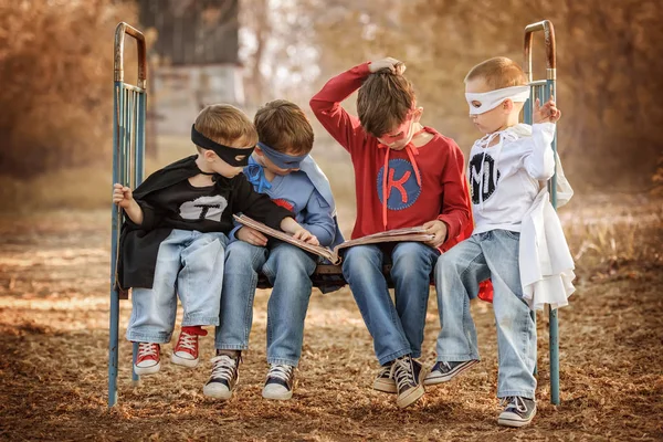 Vier als Superhelden verkleidete Jungs zeigen die Macht des jeweils anderen — Stockfoto