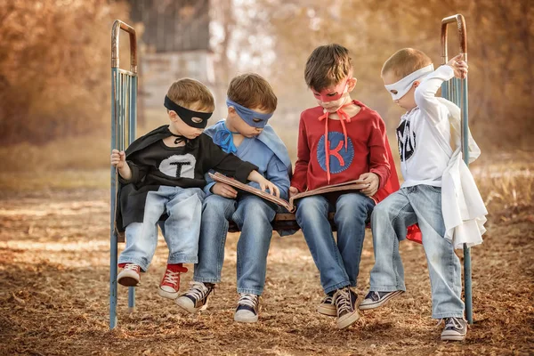 Quatro meninos vestidos de super-heróis mostram o poder um do outro — Fotografia de Stock